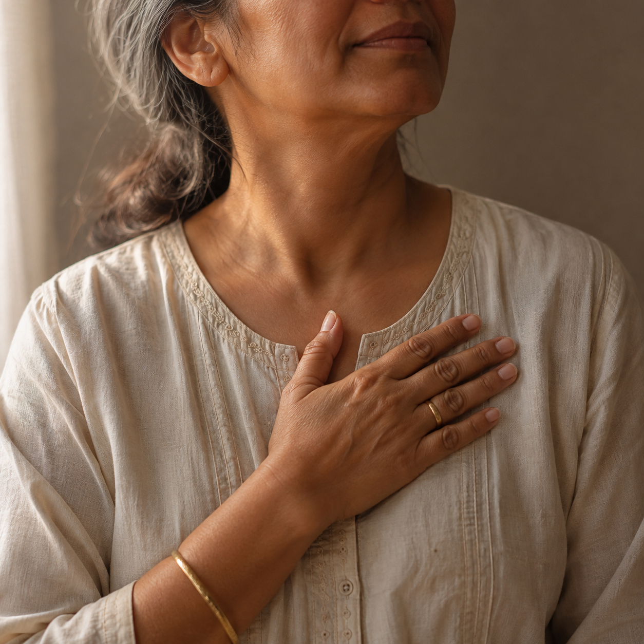 A hand resting flat on the centre of the chest during the 4-Minute Reset for perimenopause heart palpitations