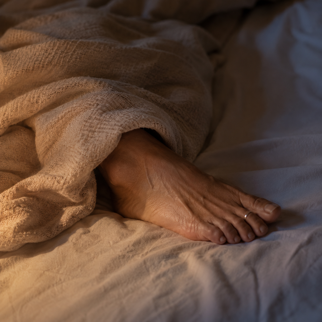 One foot slipped out from under the blanket to cool down at night